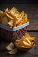 Chips in a basket on a wooden table photo