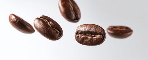 The floating coffee beans in mid-air against a light background. photo
