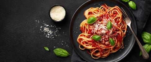The delicious spaghetti pasta served with fresh basil and grated cheese photo