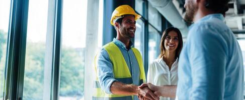 The construction manager shakes hands with clients at a modern office site. photo