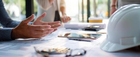 The collaborative discussion around architectural plans and project management tools. photo