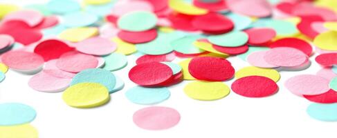 The colorful confetti scattered across a white surface creating a festive atmosphere. photo
