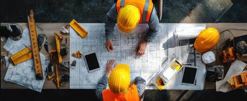 The engineers collaborating over blueprints in a modern construction workspace. photo