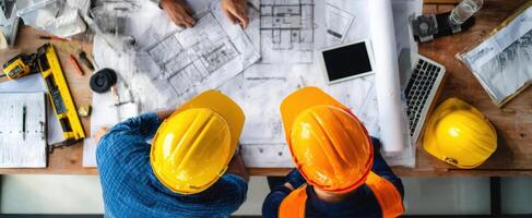 The Engineers Collaborate on Construction Plans at a Workspace Table photo