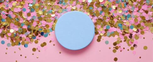 The vibrant blue circle surrounded by colorful confetti on a pink background. photo