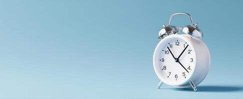 The elegant white alarm clock against a soft blue background photo