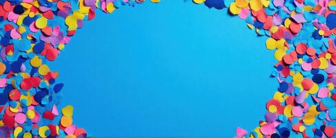 The colorful confetti surrounding a bright blue background perfect for celebrations photo