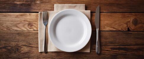 The Elegant White Plate Set on a Rustic Wooden Table for Dining Experience. photo