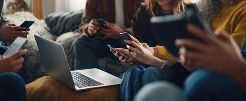 The group of friends engaging with smartphones and laptops in a cozy setting. photo