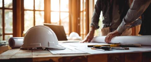 The construction planning process with blueprints and safety gear on a table. photo