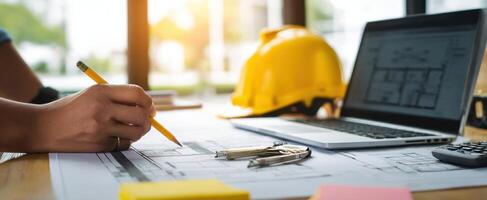 The architect drafting designs at a modern construction workspace with plans and tools. photo