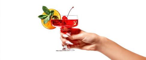 The vibrant cocktail garnished with orange, cherry, and mint in hand. photo