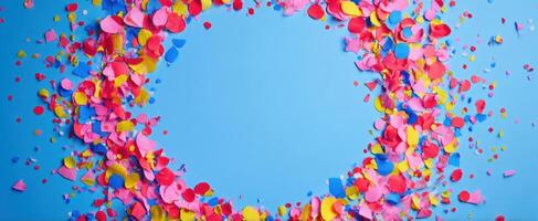 The colorful confetti circle on a blue background for festive celebrations. photo