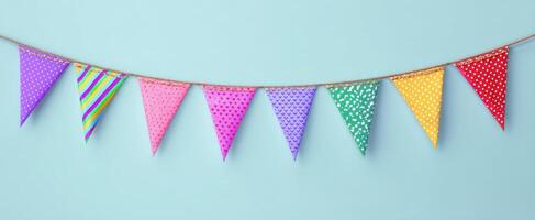 The festive bunting decoration in vibrant colors against a blue background. photo