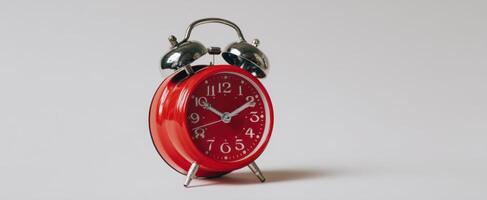 The vintage red alarm clock with metallic accents on a minimalist background. photo