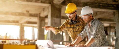 The engineers collaborating on construction plans at a job site. photo