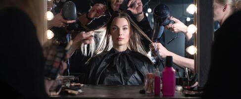 The model undergoing a glamorous hairstyling transformation in a professional salon. photo