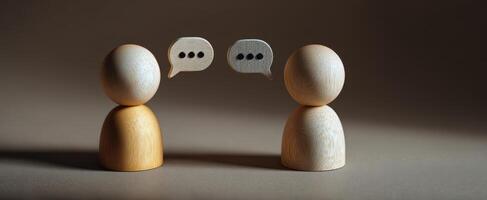 The wooden figures engaged in a thoughtful conversation with speech bubbles. photo