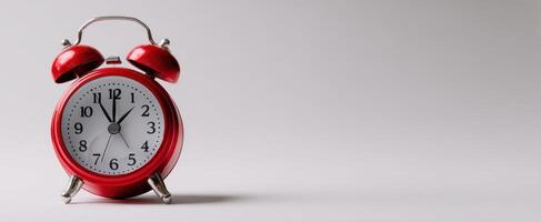 The red alarm clock standing on a minimalistic background showing the time. photo