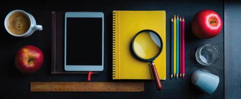 The creative workspace featuring a tablet, notebooks, and vibrant stationery items. photo