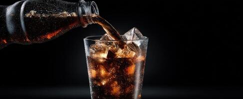 The pouring of cola into a glass filled with ice and bubbles. photo