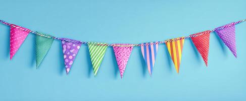 The colorful bunting flags hanging against a vibrant blue background. photo
