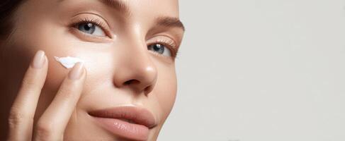 The woman applying moisturizer to enhance her skincare routine. photo