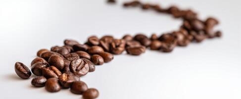 The coffee beans scattered in a creative and artistic arrangement on a white surface. photo