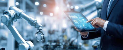 The engineer using a tablet to control robotic automation in a modern factory. photo