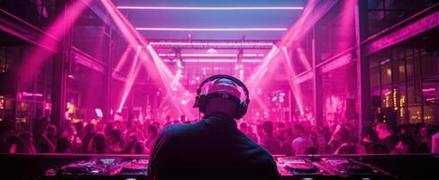 The DJ performing at an electrifying party with vibrant neon lights. photo