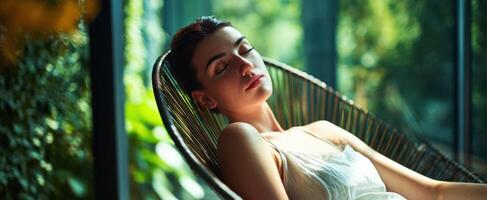 The serene woman resting in a sunlit indoor space surrounded by nature. photo