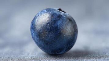 The detailed close-up of a fresh blueberry on a textured background. photo