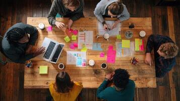 The collaborative teamwork session with diverse professionals around a wooden table. photo