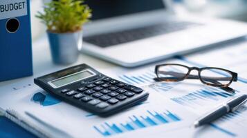 The calculator and budget documents on a well-organized workspace photo
