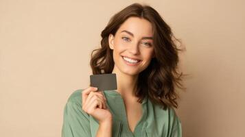 The woman joyfully holding a blank card against a neutral background. photo