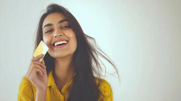 The young woman joyfully holding a credit card and smiling brightly. photo