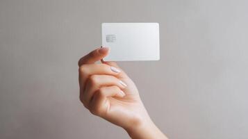 The elegant hand holding a blank white credit card against a soft background. photo