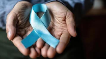 The hands holding a blue awareness ribbon symbolizing hope and support. photo