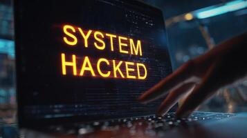 The laptop screen displays a warning about a system being hacked. photo