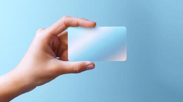 The Hand Holding a Blank Card on a Soft Blue Background photo