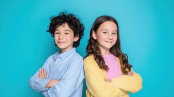 The cheerful portrait of two confident children against a vibrant blue backdrop. photo