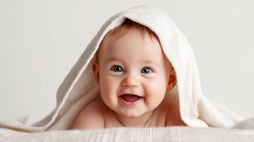 The smiling baby wrapped in a soft, cozy towel, radiating joy and innocence. photo