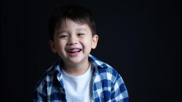 The joyful boy smiling brightly in a casual blue checkered shirt. photo