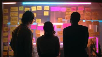 The group brainstorming ideas using colorful sticky notes on a glass wall. photo