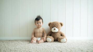 The baby sitting next to a fluffy teddy bear on a soft carpet. photo