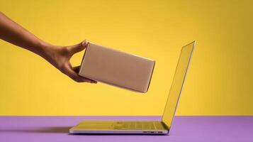 The hand delivering a package to an open laptop on colorful backdrop photo