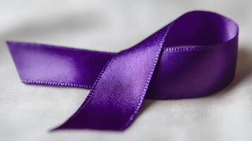 A purple ribbon laying on a white surface photo