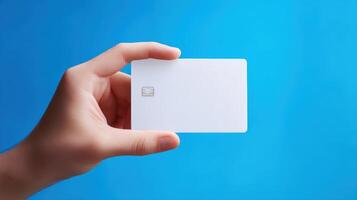 The hand holding a blank card against a vibrant blue background photo