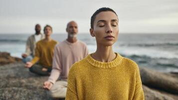 The serene moment of meditation by the ocean with four practitioners. photo