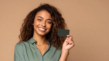 The smiling young woman holding a card against a neutral background. photo